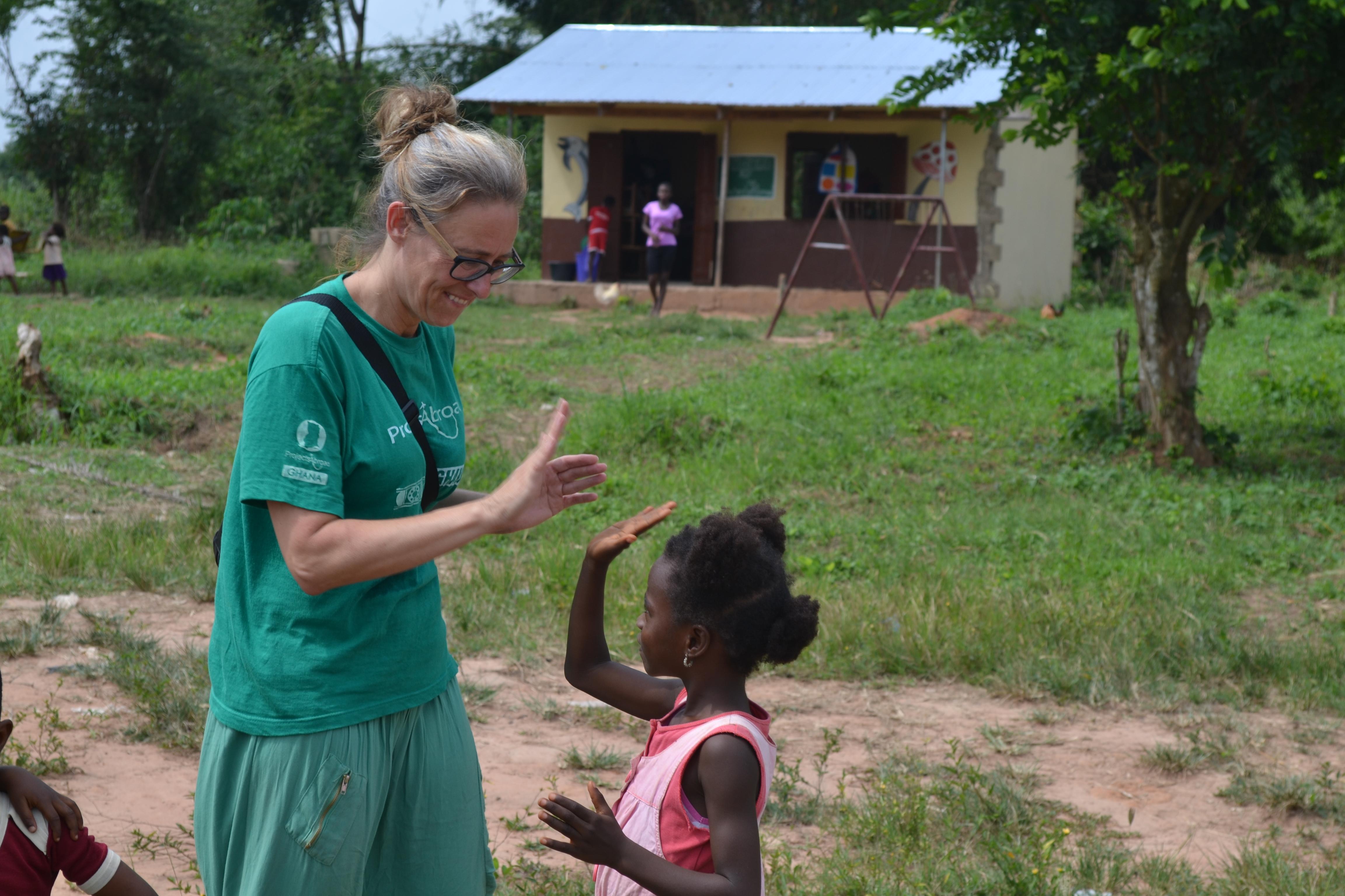A Projects Abroad speech therapy intern in Ghana gives a young girl a high five after a session the local placement. In Ghana, a young girl and intern play a game after a speech therapy session.